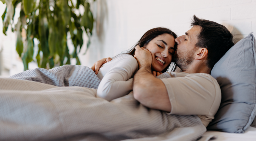 Happy couple embracing under cozy blanket