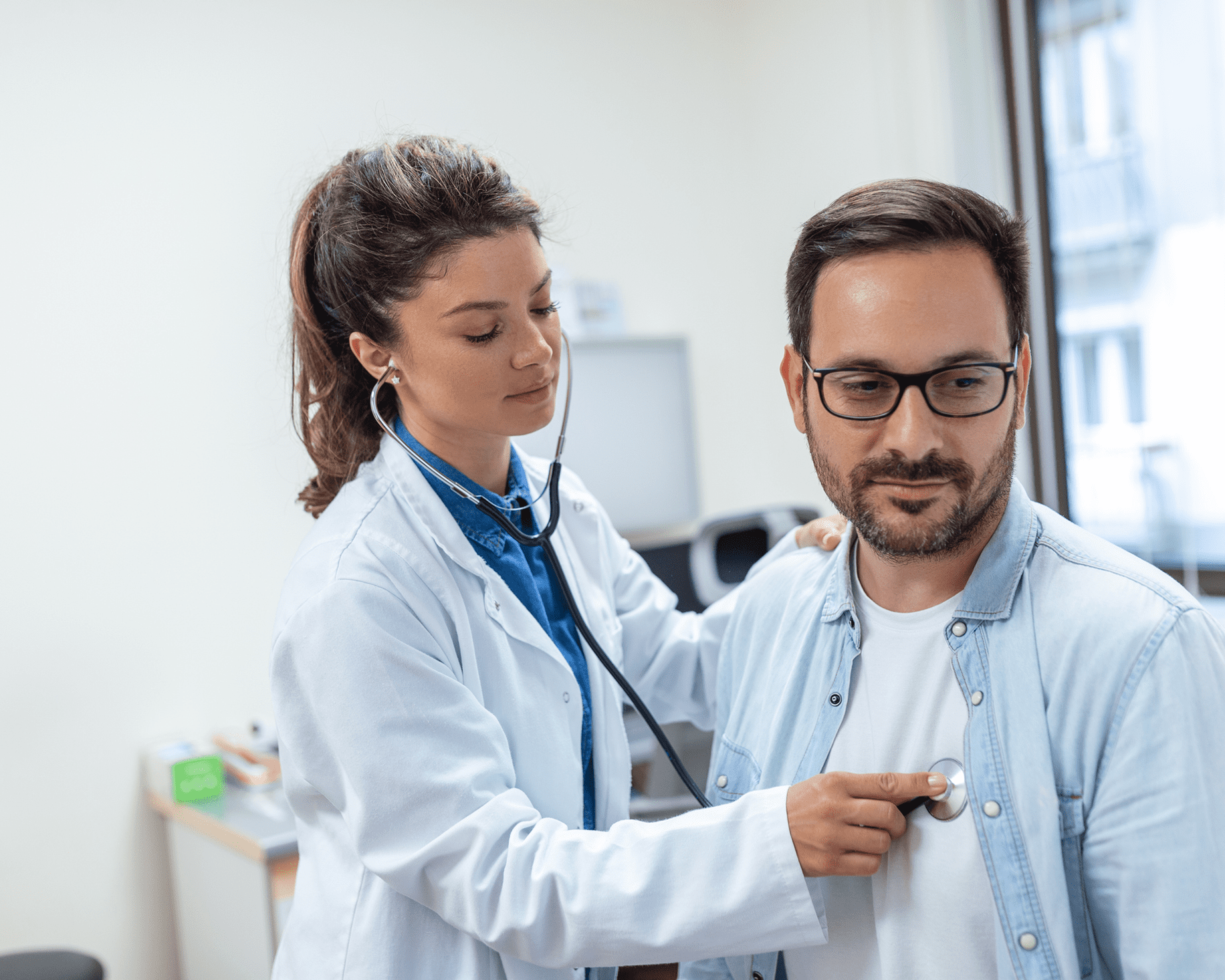 Doctor using stethoscope on patient