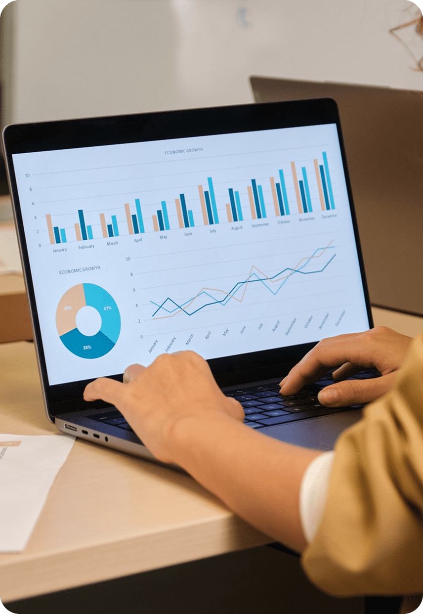 Hands typing beside statistical graphs display
