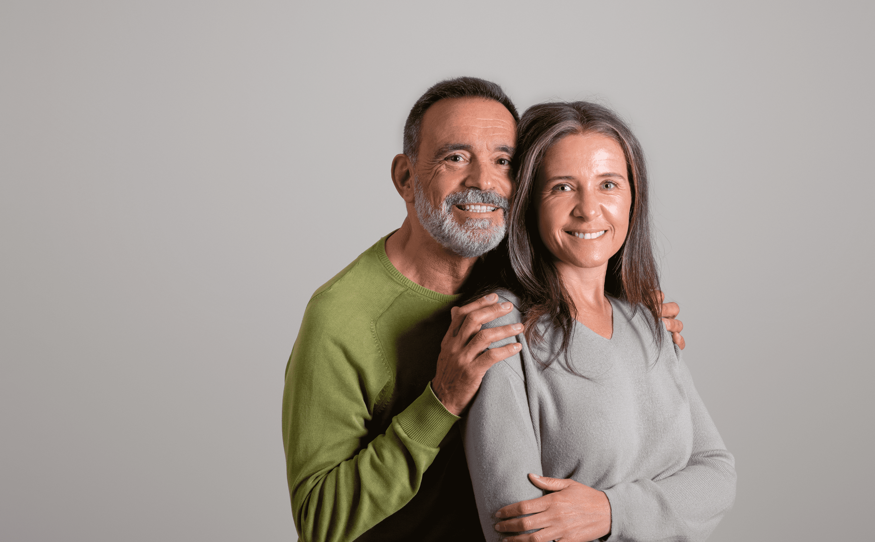 Mature couple smiling warmly at camera.