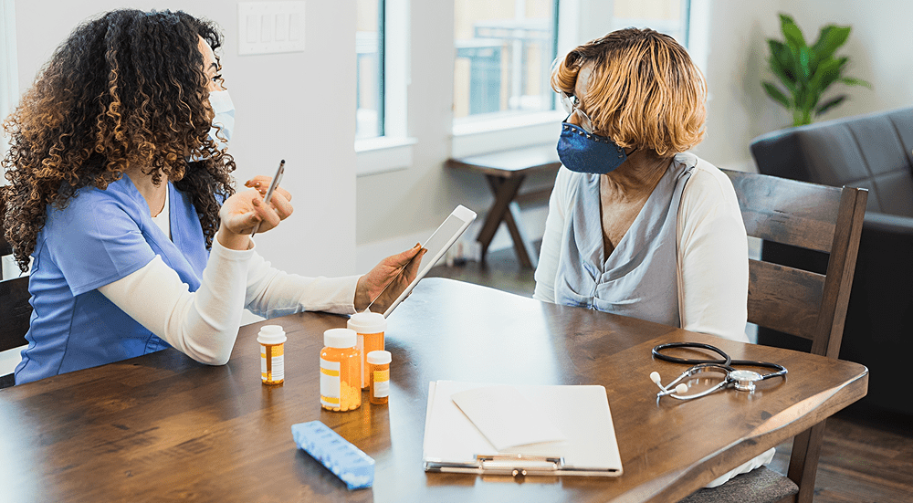 Healthcare worker consulting with elderly patient.