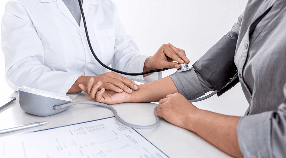 Doctor checking patient's blood pressure.