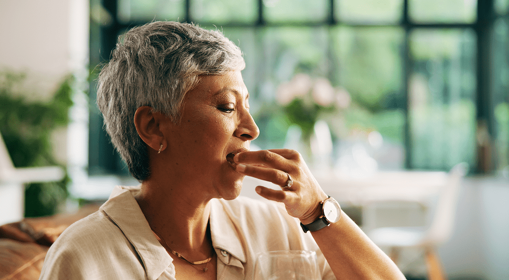Woman enjoying a snack in bright room.