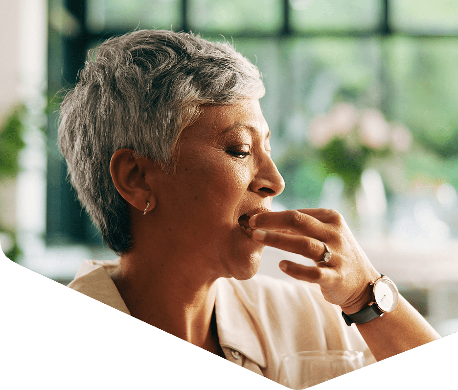 Woman enjoying a snack in bright room.
