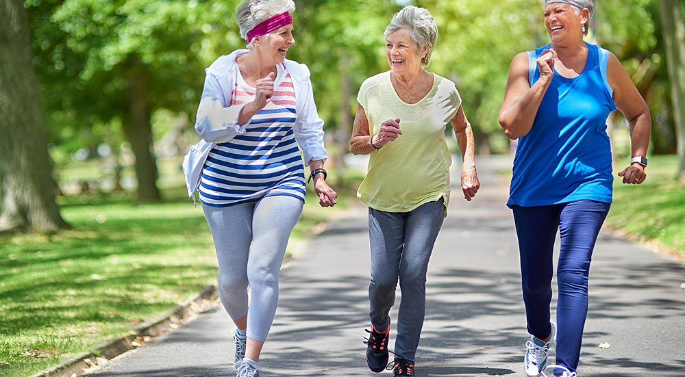 Three women jogging in a park.