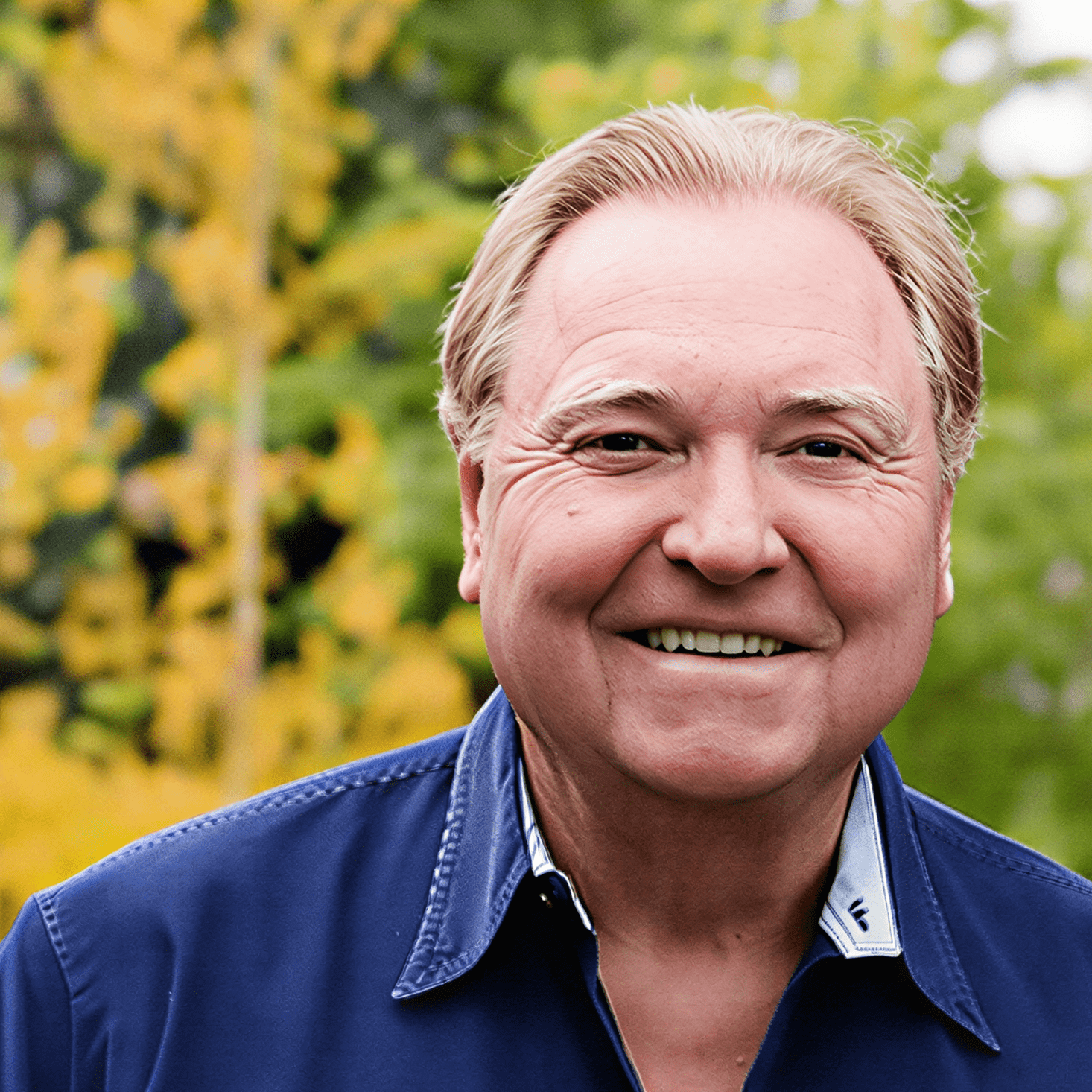 Man in blue shirt, nature backdrop.